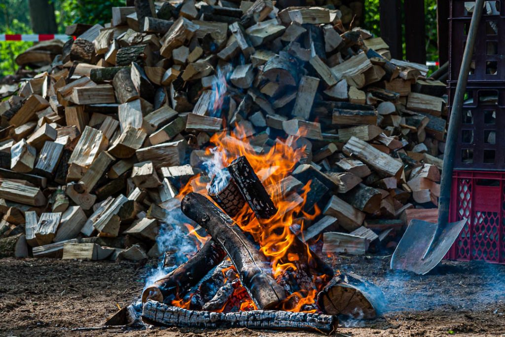 A fire in front of a heap of wood / © Foto: Georg Berg