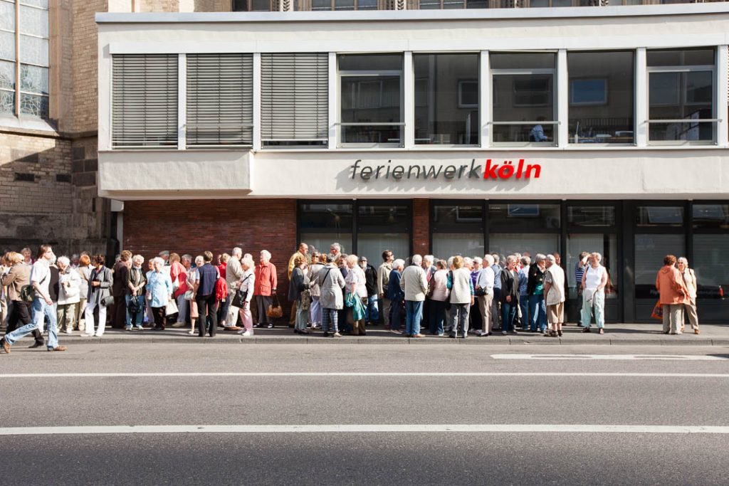 Pensioners waiting in front of a travel agencyferienwerk kölnPileInternation / © Foto: Georg Berg