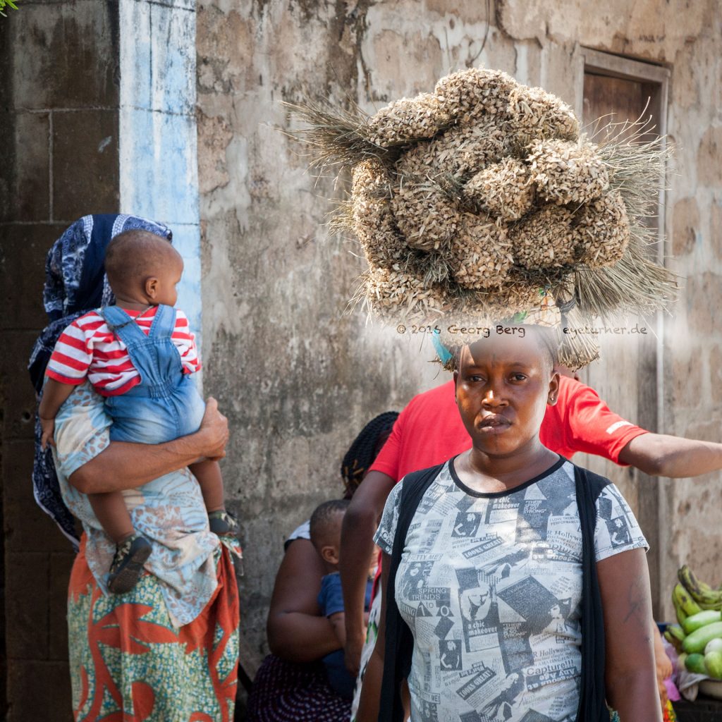Frau aus Sierra Leone mit Bürsten auf dem Kopf
