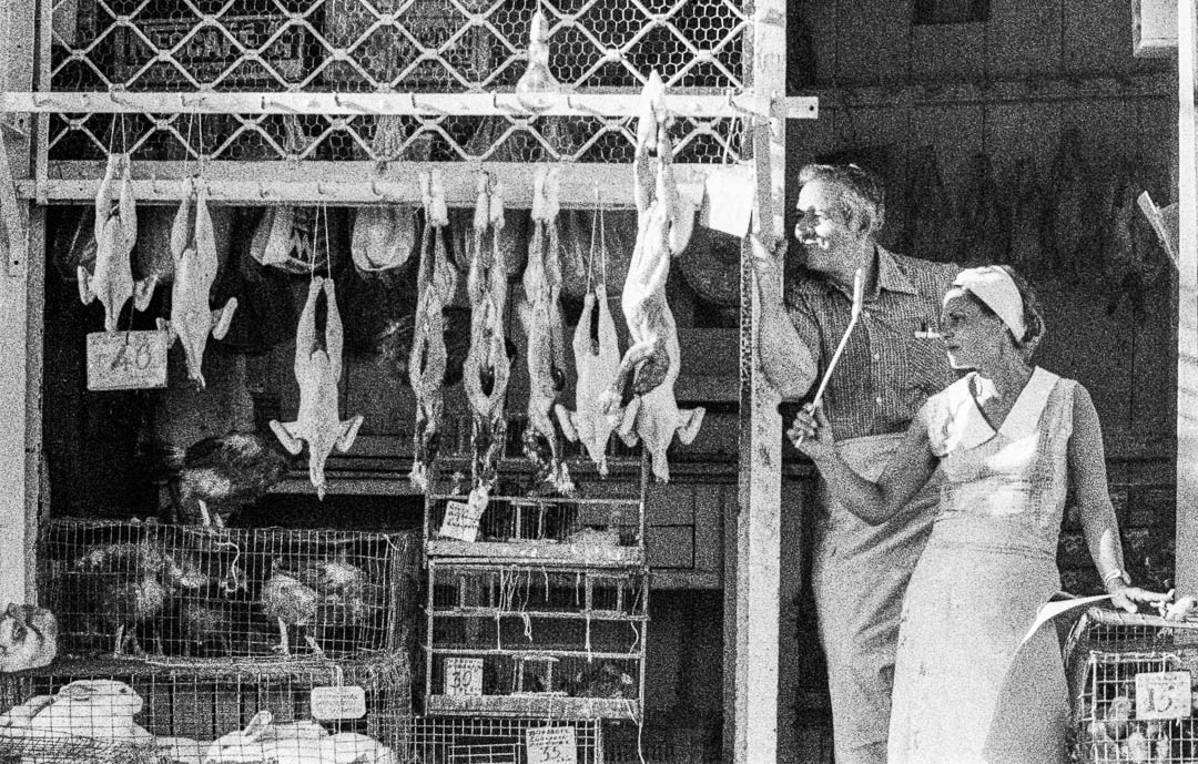 Butcher Couple with living animals in Greece.  Woman is smoking and hunting flies with a  flyswatter / © Foto: Georg Berg
